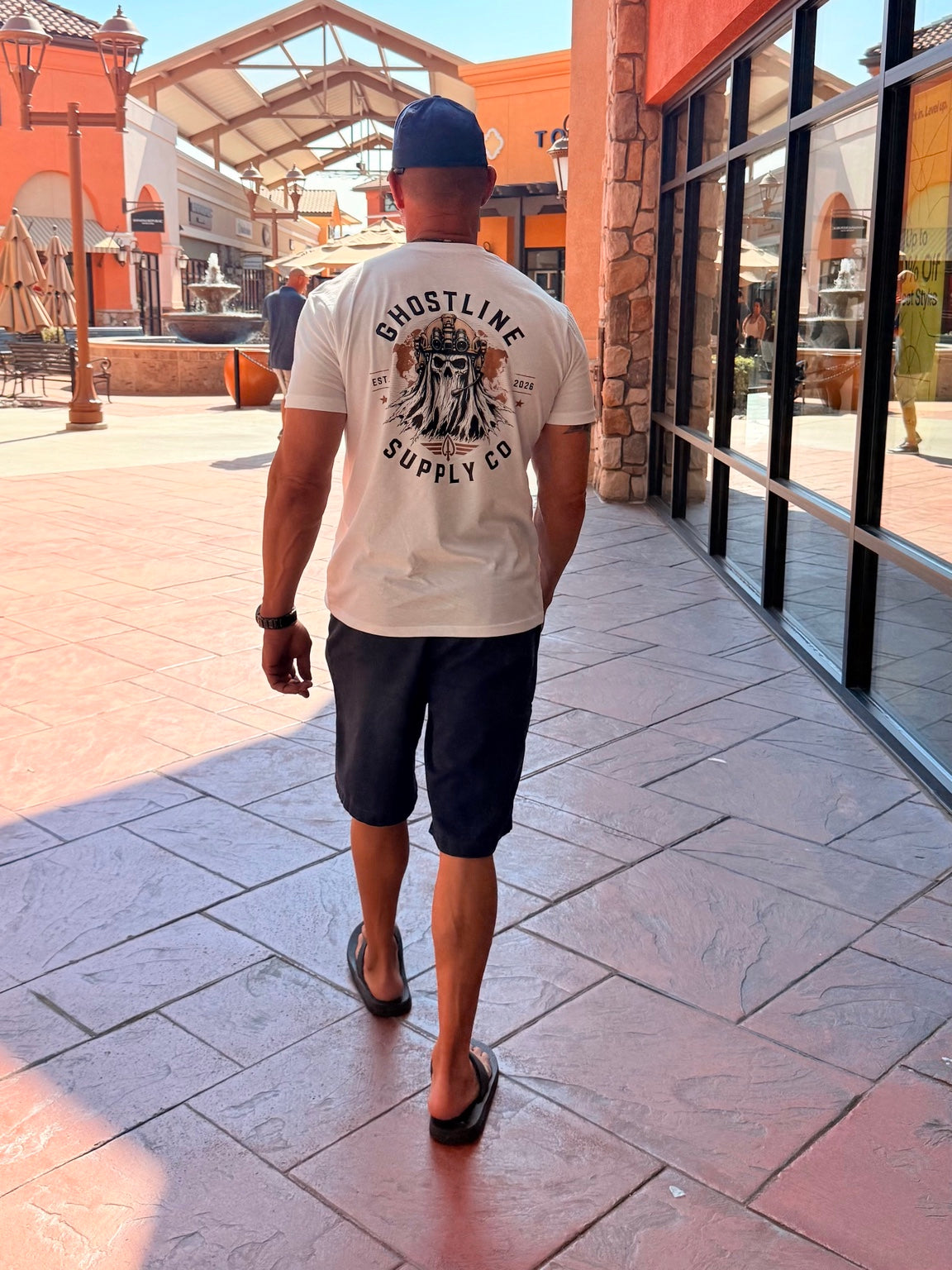 The white Ghostline OG Tee worn outdoors, showing the back graphic and fit.
